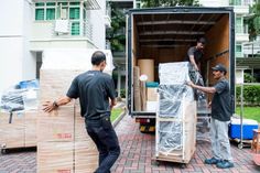 two men unloading boxes from the back of a moving truck