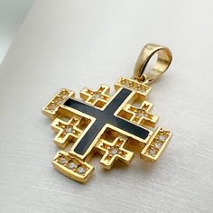 Immerse yourself in divine elegance with our 14k Gold Jerusalem Cross Pendant, adorned with Black Enamel and Zircons, a harmonious blend of spiritual significance and exquisite craftsmanship. 🌟 Meaning of the Jerusalem Cross: The Jerusalem Cross, with its distinctive design featuring four smaller crosses surrounding a central one, holds deep religious symbolism. Each arm represents the foundational Christian virtues of faith, hope, love, and the central message of the Gospel. ⛪️ Pointing to the Symbolic Black Gemstone Jewelry, Black Cross Pendant For Formal Occasions, Symbolic Black 14k Gold Jewelry, Black Symbolic Jewelry For Anniversary, Black Symbolic Anniversary Jewelry, Symbolic Black Jewelry For Anniversary, Black Cross Jewelry For Formal Occasions, Traditional Black Jewelry With Polished Finish, Traditional Black Hallmarked Jewelry