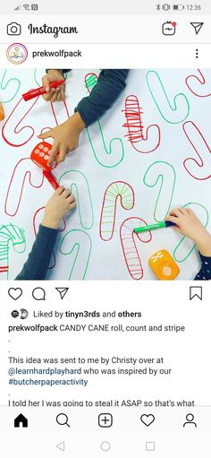 two children are drawing letters on a sheet of paper