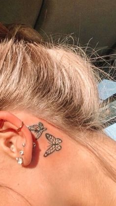 a woman with a butterfly tattoo on her left side behind the ear is laying down