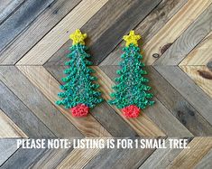 two small christmas trees made out of yarn on top of a wooden floor with the words please note listing is for small tree