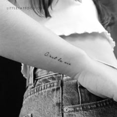 a woman's arm with a small tattoo on it