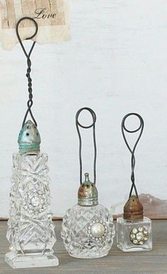 three glass vases sitting on top of a wooden table