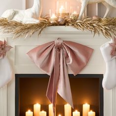 a mantel with candles, stockings and deer figurines in front of it