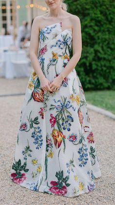 a woman in a floral dress standing on gravel