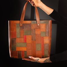 a person holding a brown and green bag in their hand with tattoos on the arm