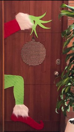 the door is decorated with green and red christmas stockings, santa's stocking hat, and an ornament