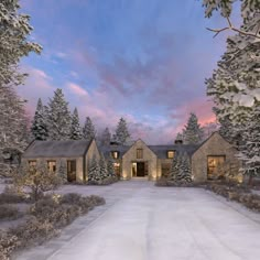 a large house in the middle of a snow covered field with trees on both sides