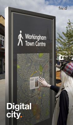 a woman standing next to a sign that says workingham town centre