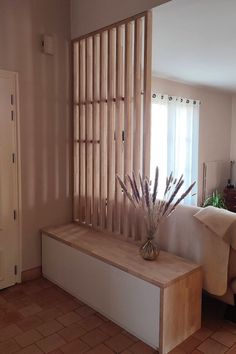 a living room with a couch, window and wooden slats