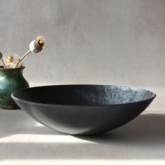 two black bowls sitting next to each other on a table