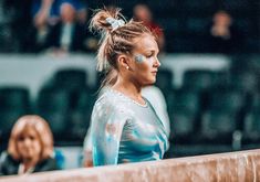 a woman with blue paint on her face is standing in front of a wall and spectators