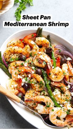 a white bowl filled with shrimp, asparagus and olives