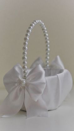 a white basket with pearls and a bow