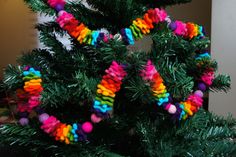 a colorful christmas tree decorated with pom - poms