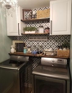 a washer and dryer in a small laundry room with black and white wallpaper