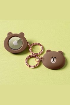 two brown bear shaped key chains on a green surface