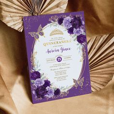 an elegant purple and gold quinceauera wedding card with flowers on it, surrounded by paper fans