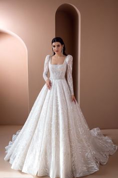 a woman in a white wedding dress standing next to an archway with her hands on her hips