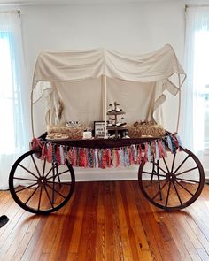 an old fashioned wagon is set up for a baby's first birthday party with clothes draped over it