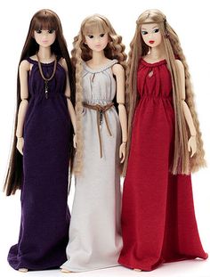 three dolls standing next to each other wearing long dresses and fur stoles on their heads