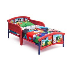 a small child's bed with mickey mouse and friends sheets on top of it