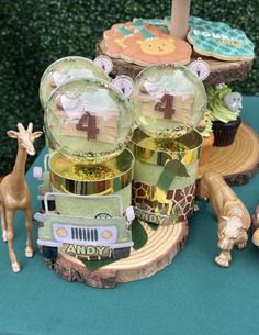 a table topped with cupcakes and giraffe figurines on top of wooden slices