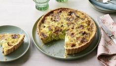 a quiche on a plate with one slice missing