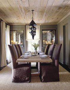 the dining room table is set with place settings for eight people and has candles on each side