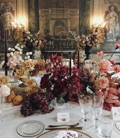 the table is set with flowers, fruit and candles for an elegant dinner or party