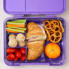 a purple lunch box filled with lots of food