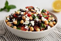 a salad with chickpeas, feta cheese and spinach in a bowl