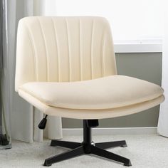 a white office chair sitting on top of a carpeted floor next to a window