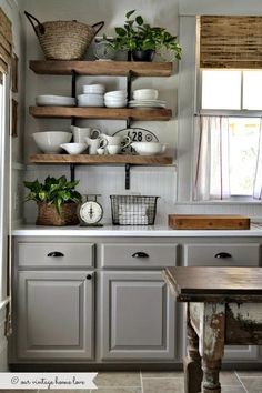 a kitchen filled with lots of counter space and open shelving above the stove top