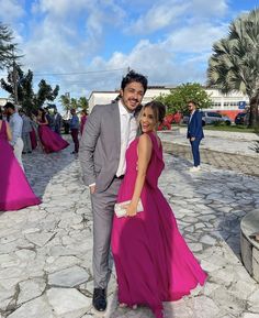 a man and woman standing next to each other in front of some pink cloths