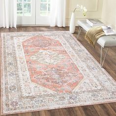 a large rug with an orange and white design on the floor in front of a window