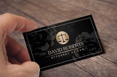 a person holding up a business card that says, david roberts attorney at law