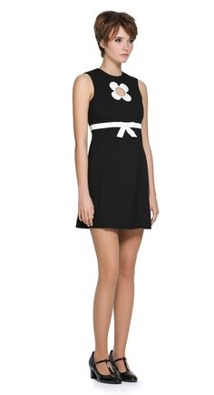 Autumn, mod style little black dress with a slight A-line, rounded neckline, detailed with a carefully sewn floral cut-out on the torso, accented by a contrasting high waist-level bow. Shown here as sleeveless, but available with alternative sleeve and hem lengths to suit preference. A simple, fun, and striking dress that's easy to reach for and pairs well with both heels and pumps. The model pictured is 178 cm tall and wears a size XS. Fabric Content: 95% CO / 5% EL. Fabric provides some stretch. Back zipper. Not lined. Machine Washable. 30 degrees. Produced in the EU from Italian mill fabric. As all of our garments are hand-made upon receipt of order, please allow approximately 4 weeks for delivery. Spring A-line Mini Dress For Formal Occasions, Spring Formal A-line Mini Dress, Formal A-line Mini Dress For Spring, Style Little Black Dress, 60s Mod Dress, Style Black Dress, Flower Cutout, Mod Dress 60s, Mod Style