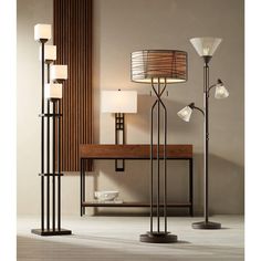 the floor lamp is next to a table with three lamps on it and a wooden shelf