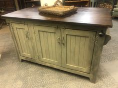 a kitchen island made out of an old cabinet and cupboards in a room filled with furniture