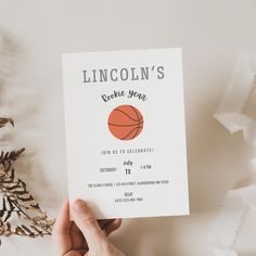 a person holding up a card that says lincoln's basketball year, with an image of a basketball on it