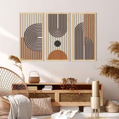 two abstract paintings hang on the wall above a wooden table and wicker chairs in a living room