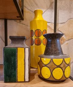 three vases sitting on top of a wooden table