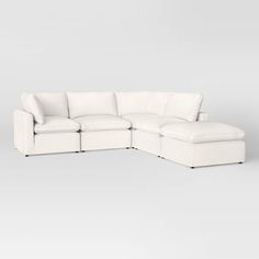 a white leather sectional sofa sitting on top of a gray floor