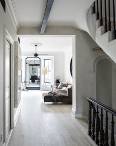 a living room filled with furniture and a stair case next to a staircase leading up to the second floor