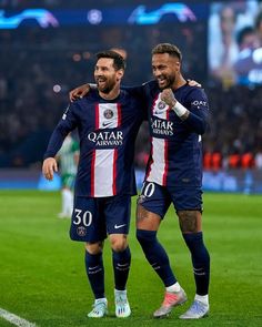 two soccer players are celebrating on the field