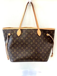 LOUIS VUITTON MONOGRAM NEVERFULL MM TOTE BAG The Neverfull MM tote unites timeless design with heritage details. Made from supple Monogram canvas with natural cowhide trim, it is roomy yet not bulky, with side laces that cinch for a sleek allure or loosen for a casual look. Slim, comfortable handles slip easily over the shoulder or arm. Lined in colorful textile, FEATURES: Beige Monogram coated canvas Natural cowhide-leather trim Striped textile lining Gold-color hardware Hook closure Flat, text Louis Vuitton Monogram Neverfull, Louis Vuitton Gifts, Louis Vuitton Monogram Bag, Louis Vuitton Travel Bags, Louis Vuitton Travel, Louis Vuitton Neverfull Monogram, Monogram Neverfull, Colorful Textiles, Neverfull Mm Monogram