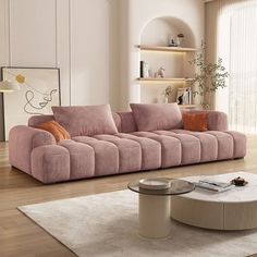 a living room with a pink couch and coffee table on the floor in front of a large window