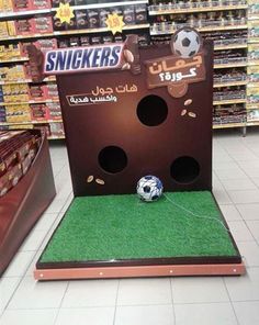 a display in a store with a soccer ball on the ground and other items for sale