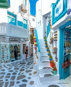 a narrow street with shops and people walking down it